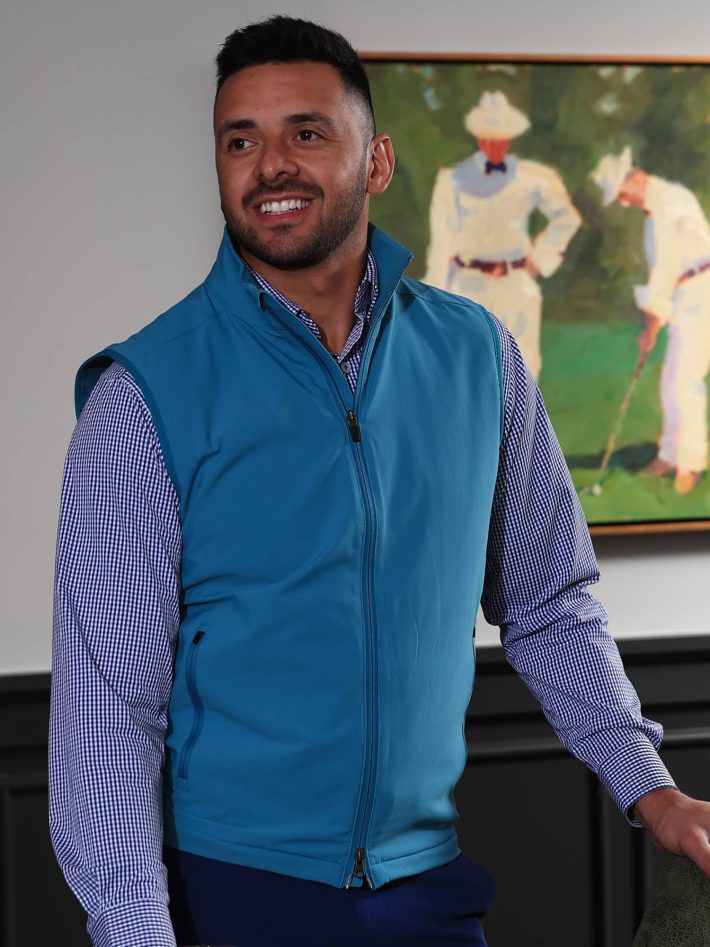 Man standing wearing a nylon fleece lined vest in teal.