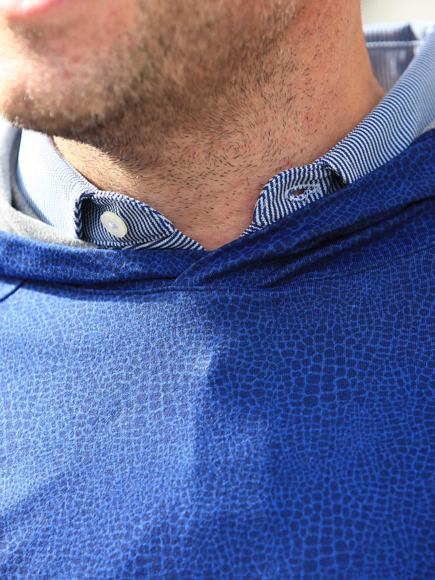Close-up of a men's printed golf hoodie in alligator print.